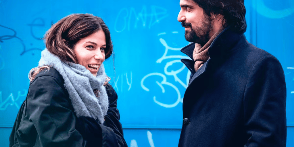 Ana y Óscar de Los años nuevos sonriendo sobre fondo azul